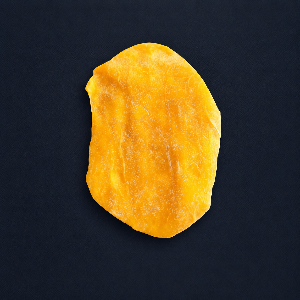 Single Thai soft dried mango slice on a dark navy background